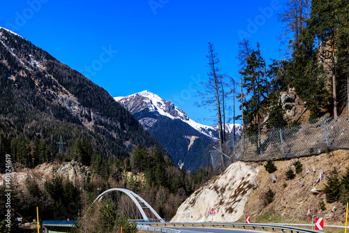 Obraz na płótnie Mountain bridge crossing alpine river in early spring landscape.. w salonie