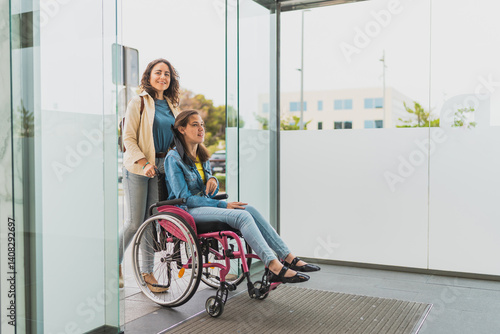 Obraz na plátně Young woman with cerebral palsy enters building with her personal assistant - Th