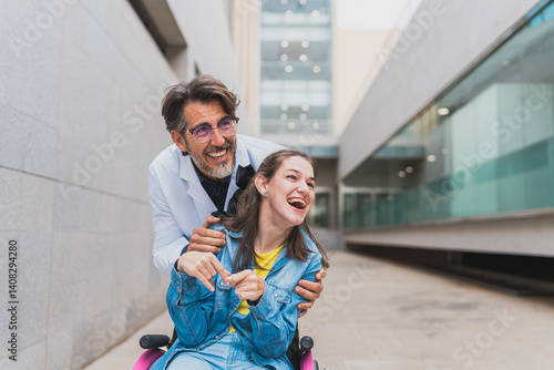 Obraz na plátně Doctor hugging cheerful young woman with cerebral palsy in wheelchair - Warm enc