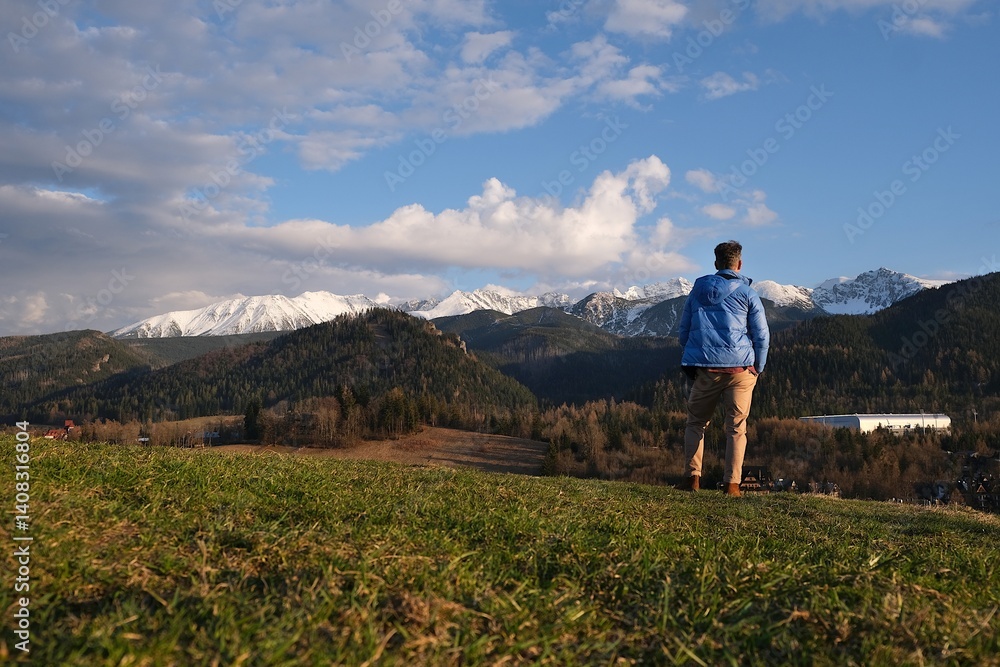 Silhouette of standing man in blue jacket on beautiful viewpoint with Tatras mountains on Antalowka, Zakopane, Poland