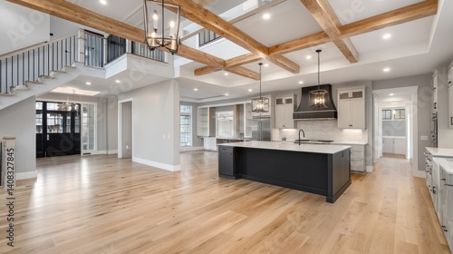 Kitchen interior in new farmhouse style luxury home with open concept floor plan. Features large island with farmhouse sink, hardwood floors, and black accents. 