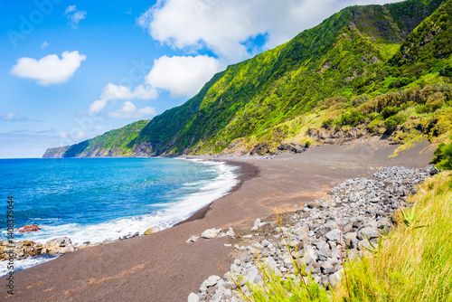 Obraz na płótnie Black sand volcanic beach of Faja and green tropical landscape with high cliffs on ocean coast, Faial island, Azores, Portugal w salonie