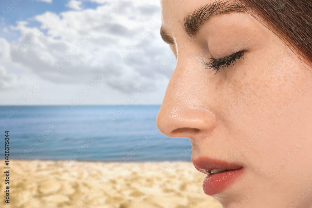 Obraz premium Beautiful young woman with freckles on beach, closeup