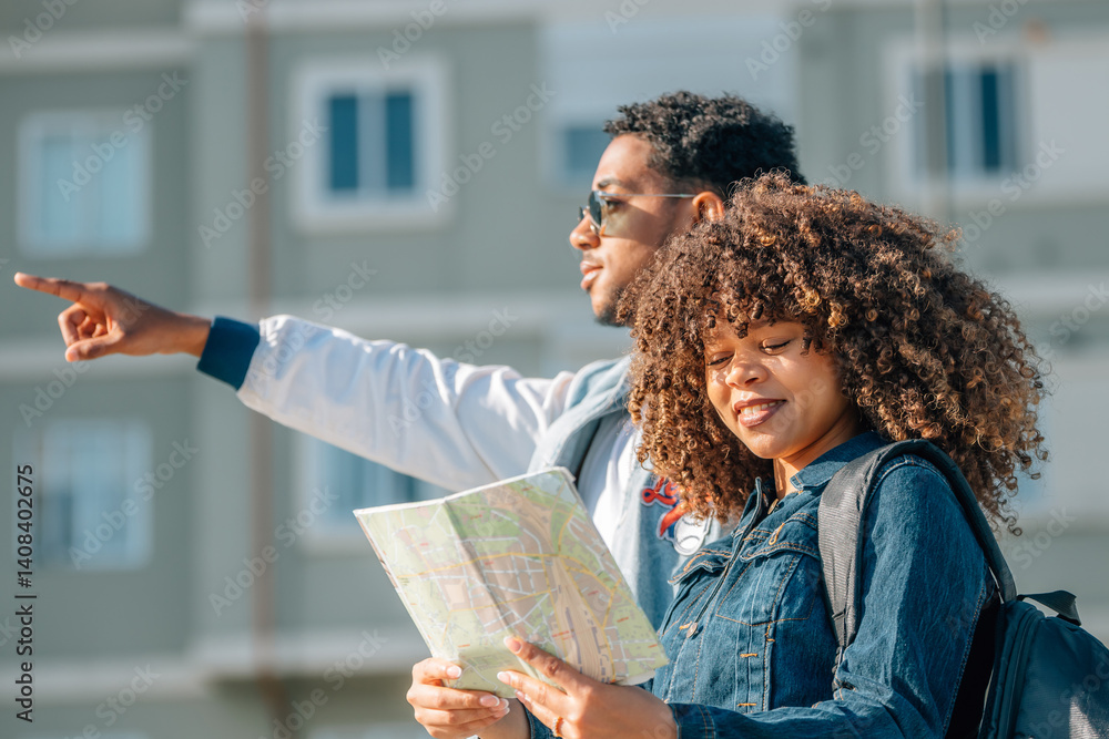 young latin couple traveling with a map in summer outdoors