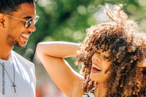 young Latin couple smiling happily in summer outdoors