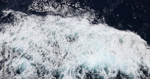 40 second video view from the balcony of a cruise ship looking down at water surface waves and foamy white wake coming from fast moving cruise ship.