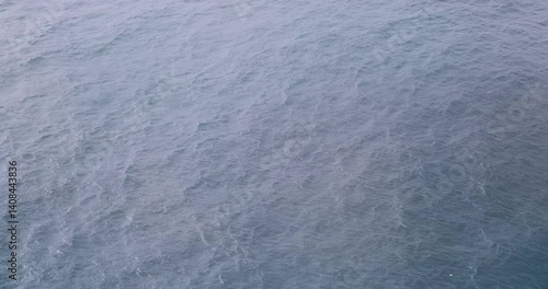 4k 45 second footage clip of looking down at ocean surface from cruise ship on a bright overcast day
