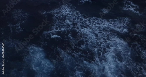 4k video footage from the side of a moving cruise ship looking down at wake and waves from ship.