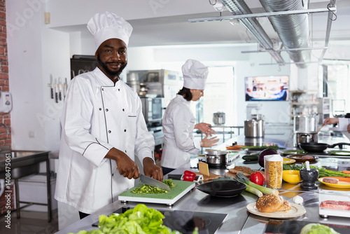 African american head chef chopping veggies at the kitchen counter, using stainless steel tools to cook a delicious gourmet dish. Culinary expert cooking with raw materials in the kitchen.