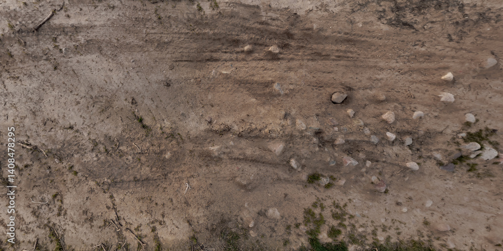 view from above on surface of texture of dry road with tractor tire tracks in countryside