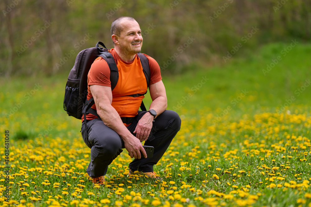 Man squatting in spring meadow