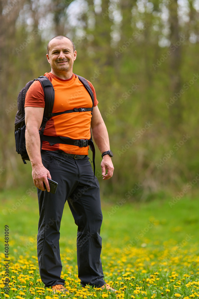 Happy man hiking in spring meadow