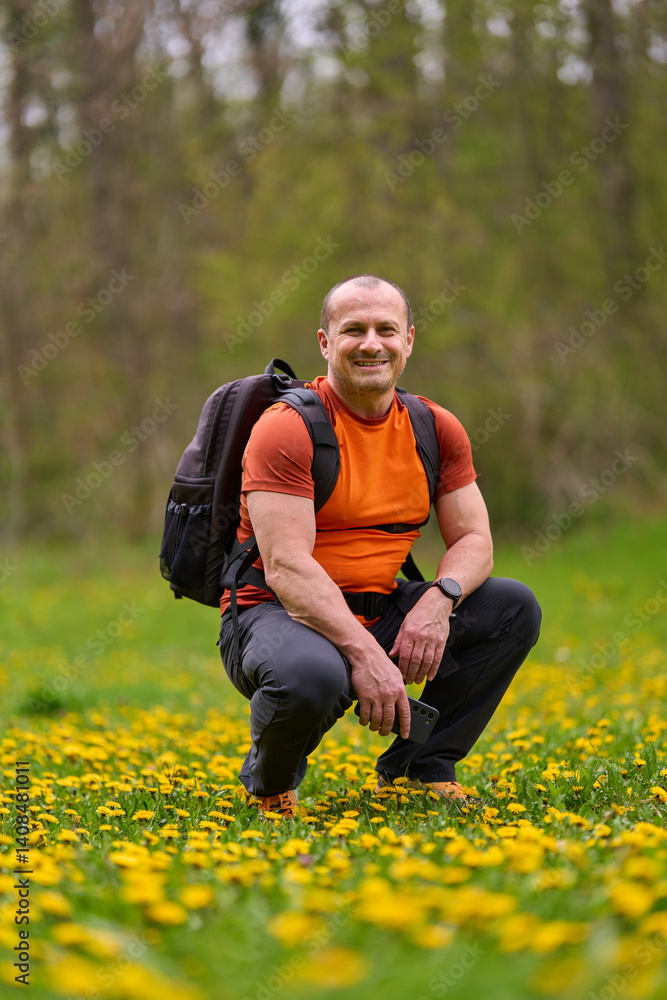 Man squatting in spring meadow