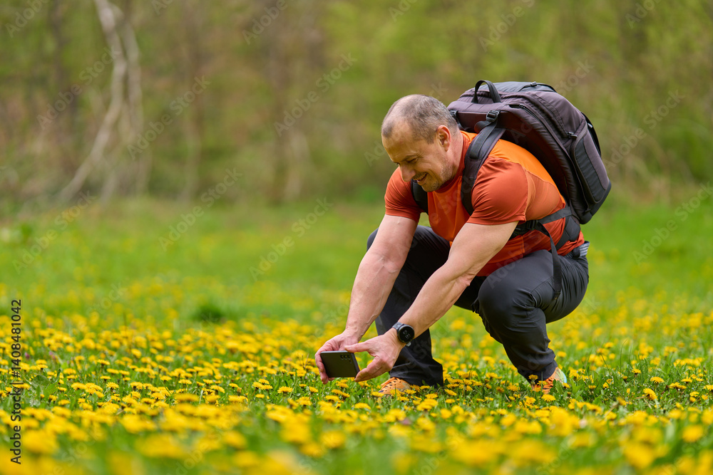 Man photographing flowers with phone