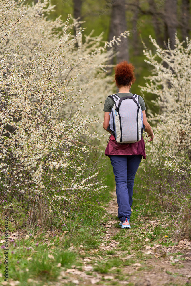Woman hiking through spring blossoms