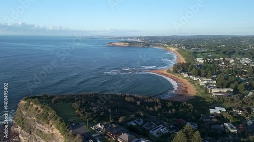 Stunning drone footage of Mona Vale Beach at sunrise, showcasing golden cliffs, serene waves, and the iconic ocean rockpool on Sydney’s Northern Beaches.