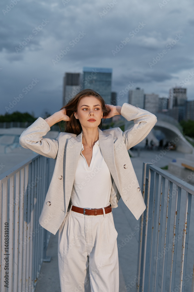 Confident businesswoman adjusting her hair against a modern city skyline, wearing a stylish outfit in neutral tones, evoking empowerment and sophistication.