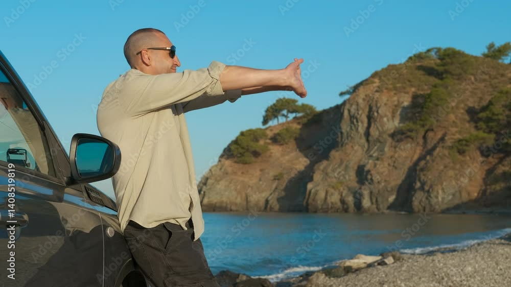 Tourist stretching arms enjoying seascape. Man stretches his arms wide, embracing the beauty of the sea while leaning against a car parked near a serene cove. Tourist stretching arms enjoying seascape. Man stretches his arms wide, embracing the beauty of the sea while leaning against a car parked near a serene cove.