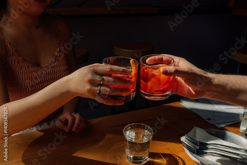 woman and man toasting with two negroni cocktails during happy hour