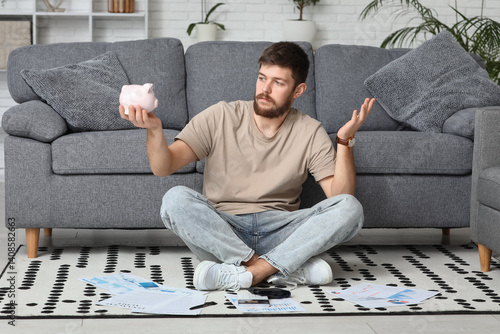 Young man in debt with pigg...