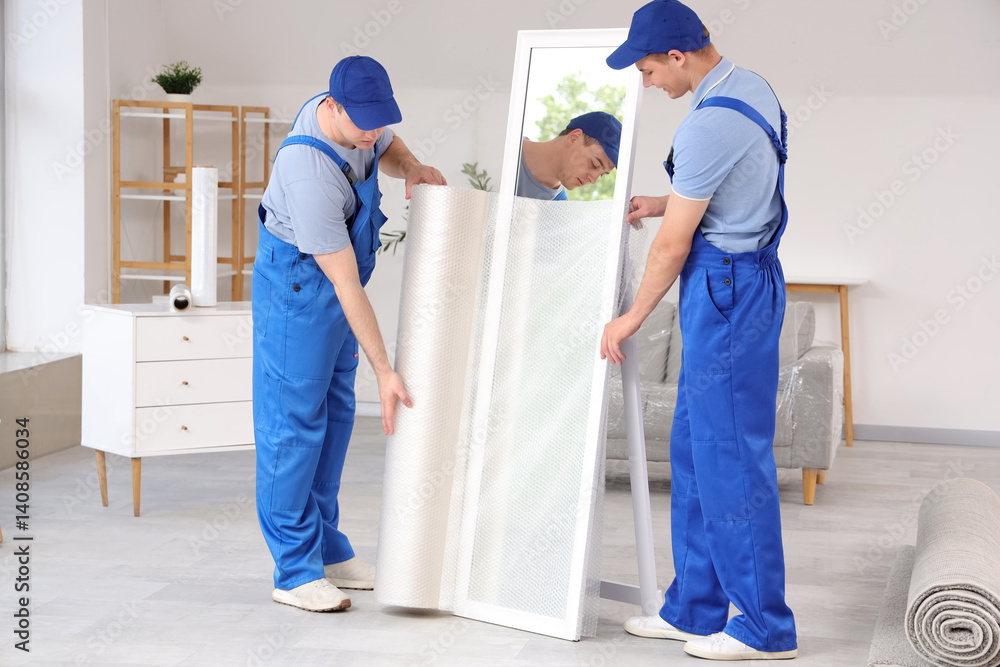 Loaders covering mirror with polyethylene film in stylish room Loaders covering mirror with polyethylene film in stylish room