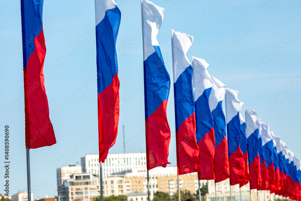 Flags of the Russian Federation hanging in a row on the street. Flags of Russia on a background of blue sky. National Flag Day, Constitution Day card.