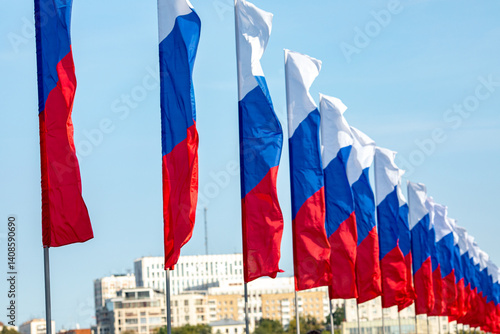 Obraz na płótnie Flags of the Russian Federation hanging in a row on the street. Flags of Russia on a background of blue sky. National Flag Day, Constitution Day card. w salonie