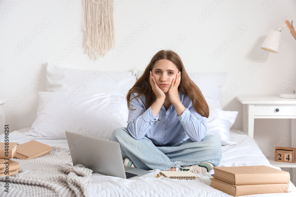 Tired female student with laptop and books studying at home Tired female student with laptop and books studying at home