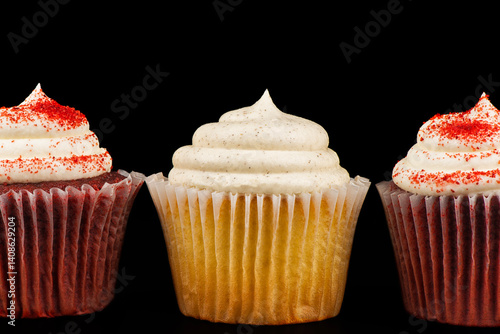 Obraz na płótnie Close-up of three gourmet cupcakes with swirled frosting, including vanilla and red velvet, set against a black background. w salonie