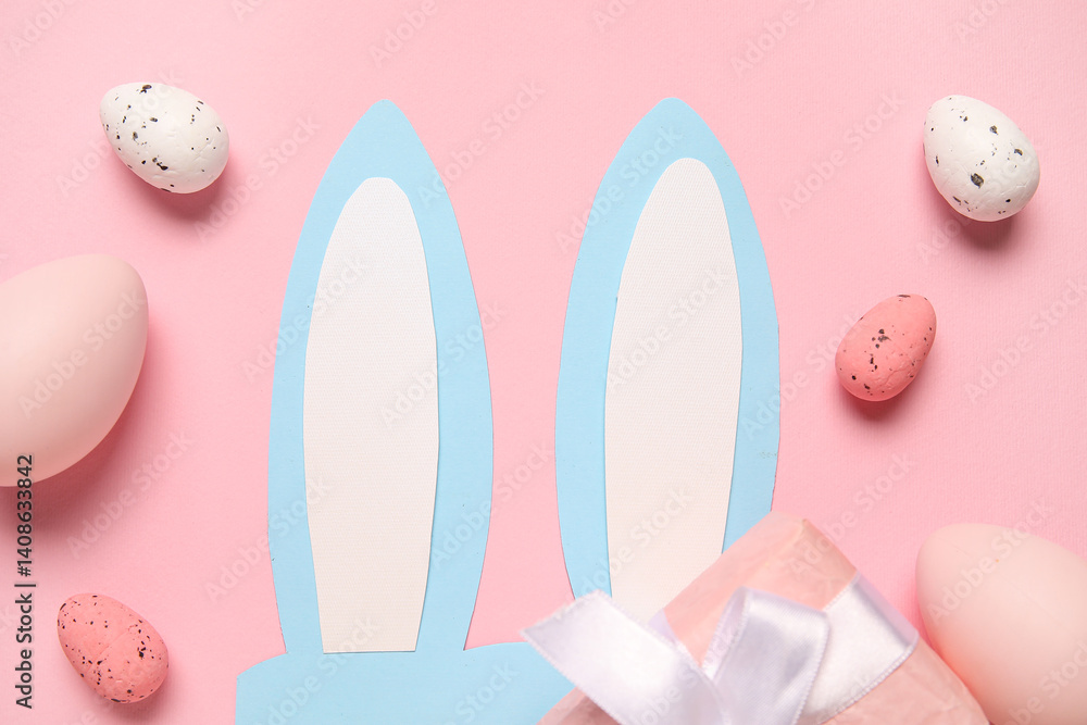 Paper bunny ears with Easter eggs and gift box on pink background