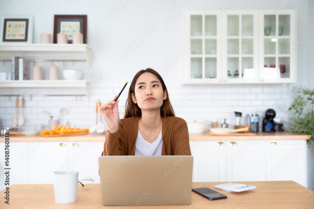 Asian young woman seriously working on computer laptop in house. She thinking find solution problem of work Asian young woman seriously working on computer laptop in house. She thinking find solution problem of work
