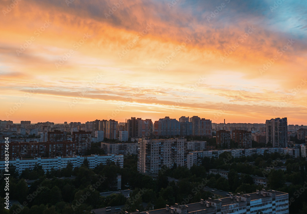 Naklejka premium Sunset over urban landscape with vibrant colors illuminating buildings in city skyline
