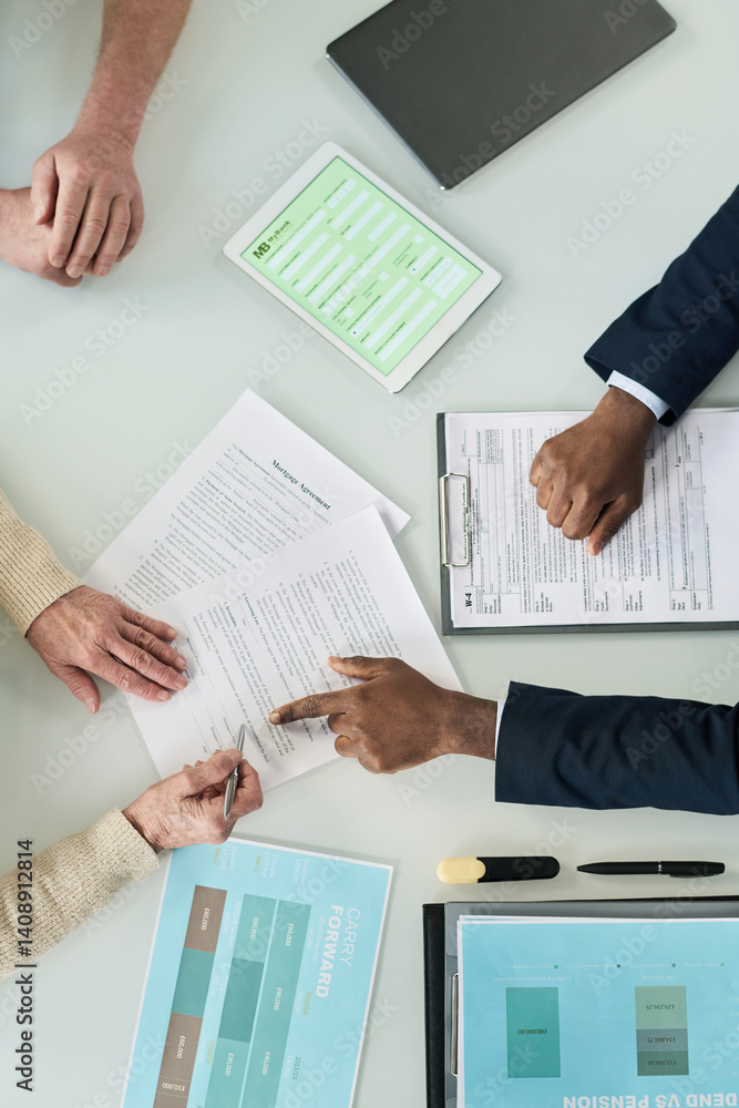 Top View of senior couple signing mortgage contract at meeting with real estate agent