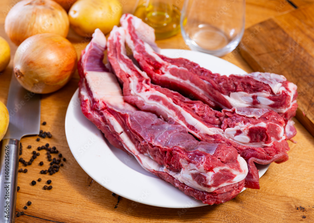 Raw beef brisket served with vegetables and seasonings