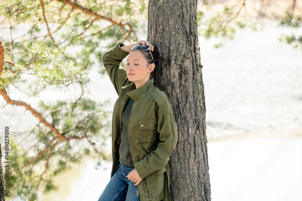 A female tourist in nature in the forest is relaxing at a campsite, happy A female tourist in nature in the forest is relaxing at a campsite, happy