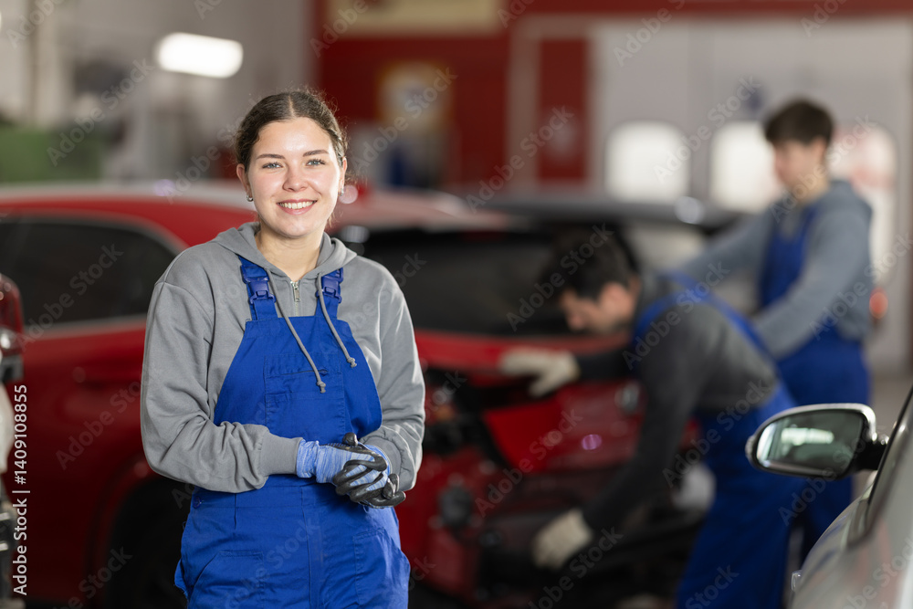 Girl employee performs repairs to external parts of car body and internal components of vehicle. Worker is busy restoring car after damage