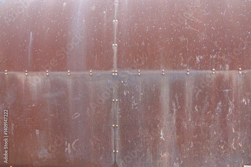 Obraz na płótnie A large metal surface shows significant signs of wear, featuring a rusty texture and visible rivets w salonie