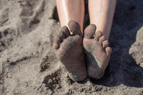 Children's feet in the sand on the beach. Travel and vacation concept. Feet on the sandy beach.