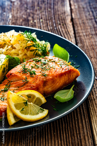 Obraz na płótnie Seared salmon steak with boiled potatoes and sauerkraut on wooden table w salonie