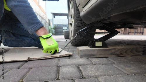 A guy changes tire on street to summer tire in nature