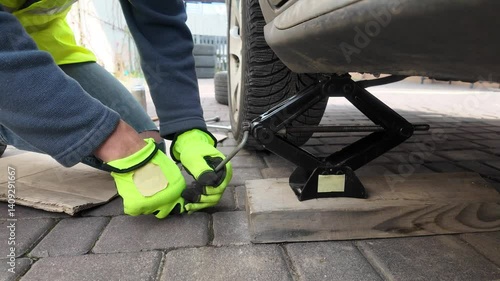 A guy changes tire on street to summer tire in nature