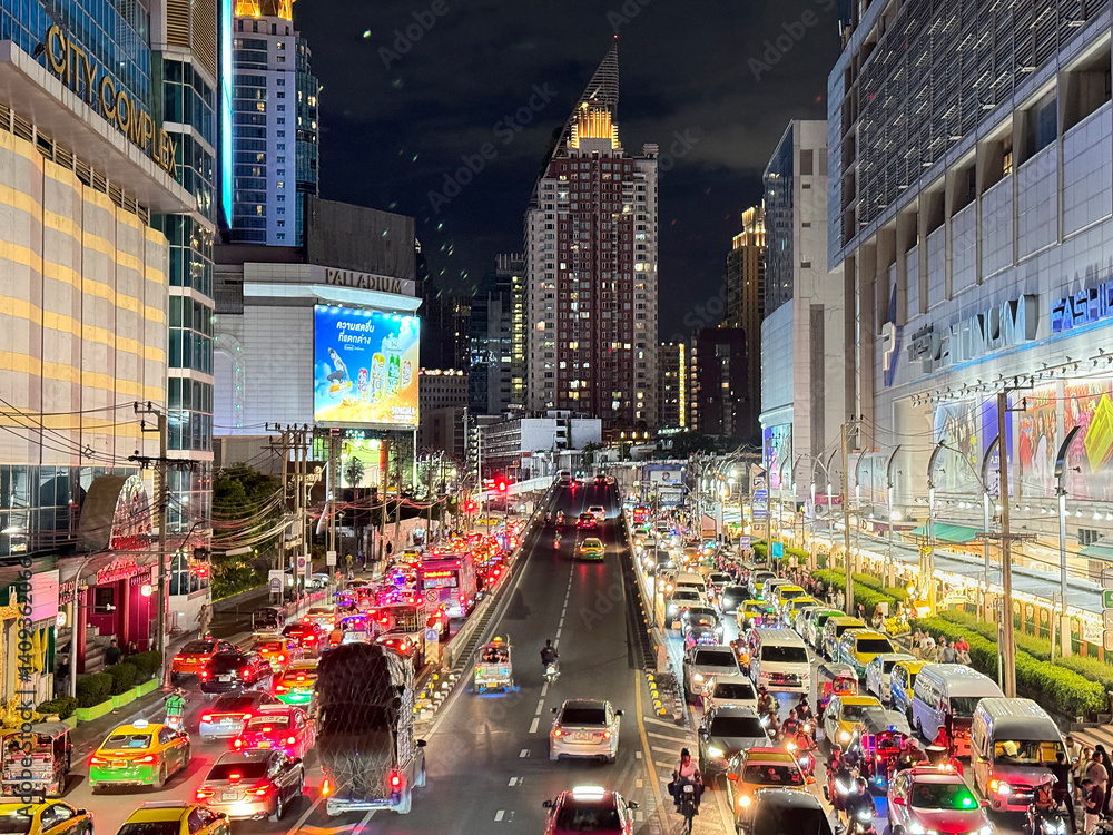 Fototapeta premium View of Bangkok busy shopping district of Pratunam and Platinum Fashion Mall, with dense traffic jam along the big road during peak hours in the evening.