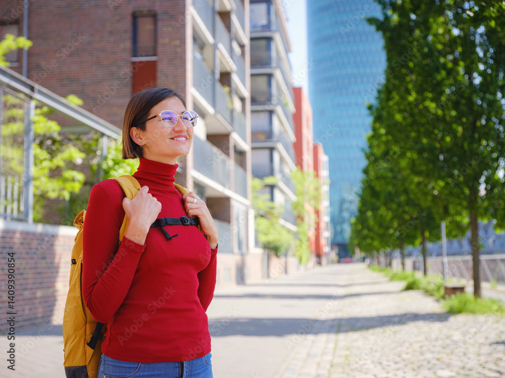 Fototapeta premium Tourist woman explores modern Frankfurt, walking through vibrant streets with contemporary architecture, skyscrapers, and urban spaces, enjoying lively atmosphere of modern side.