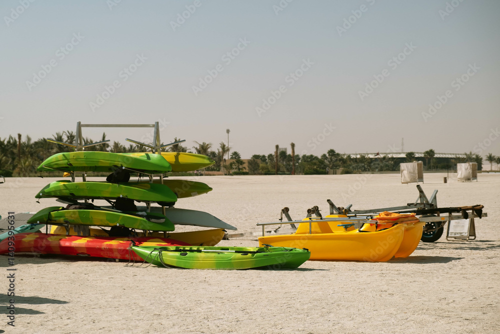 Fototapeta premium Kayaks Arranged on Sandy Beach Under Clear Sky