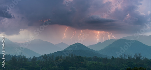 Lightning bolts strike across mountain ridges under dramatic storm clouds, capturing the power and beauty of nature during a thunderstorm over a forested landscape.