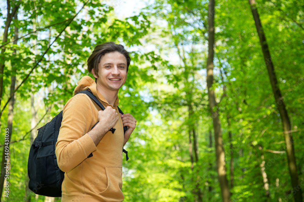 Young man traveler with backpack relaxing outdoor on green background. Summer vacations, lifestyle, hiking - concept. Young man traveler with backpack relaxing outdoor on green background. Summer vacations, lifestyle, hiking - concept.