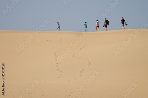 Family walking on a dune. Special Natural Reserve of the Maspalomas Dunes. Maspalomas. Gran Canaria. Canary Islands. Spain.