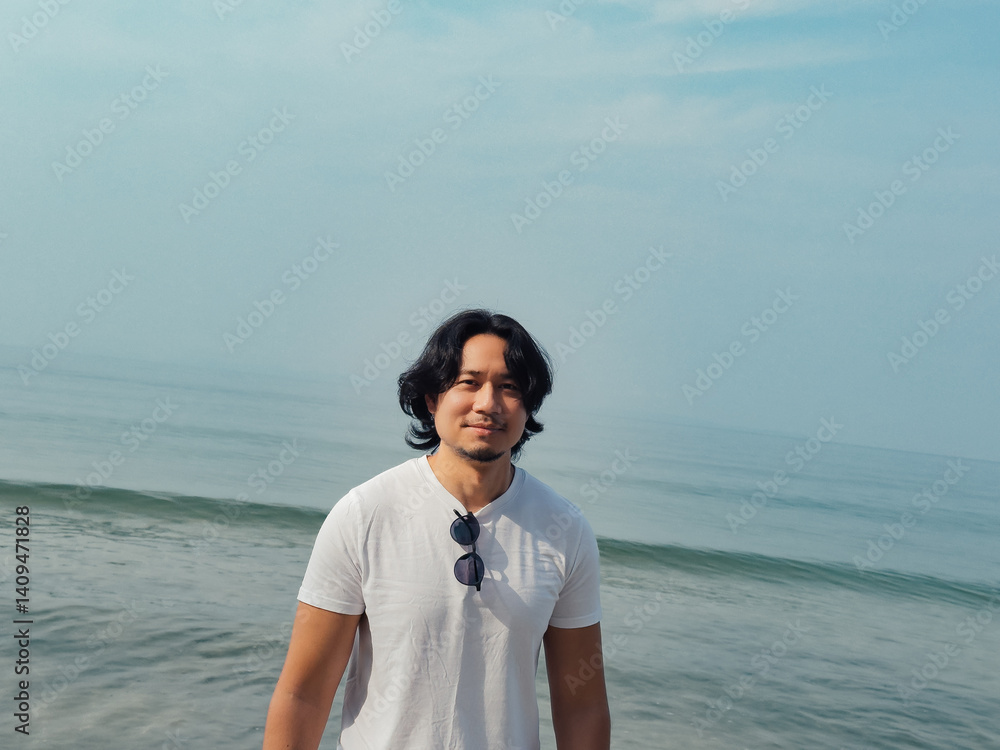 Man wears white t-shirt and sunglasses enjoy walking on the beach. Man wears white t-shirt and sunglasses enjoy walking on the beach.