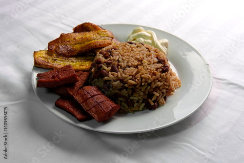 Traditional Costa Rican breakfast, rice and beans, called Gallo Pinto with eggs, tortilla, sausage and plantain.
