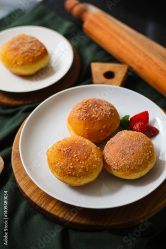 A handmade bombolone or bomboloni is an Italian-filled doughnut that is eaten as a snack or dessert. Selective focus.
